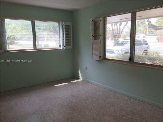 empty room featuring speckled floor and baseboards