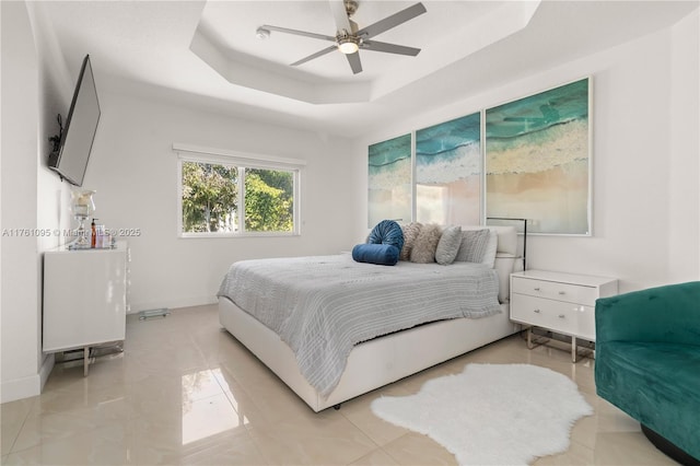 bedroom featuring baseboards, a raised ceiling, and ceiling fan