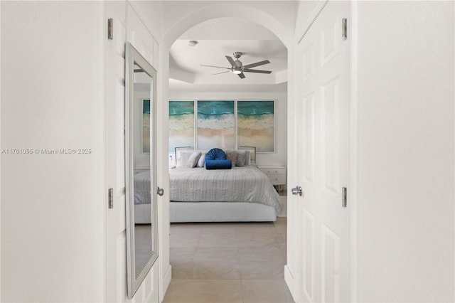 bedroom featuring arched walkways and a ceiling fan