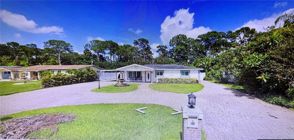 single story home with a front yard and decorative driveway