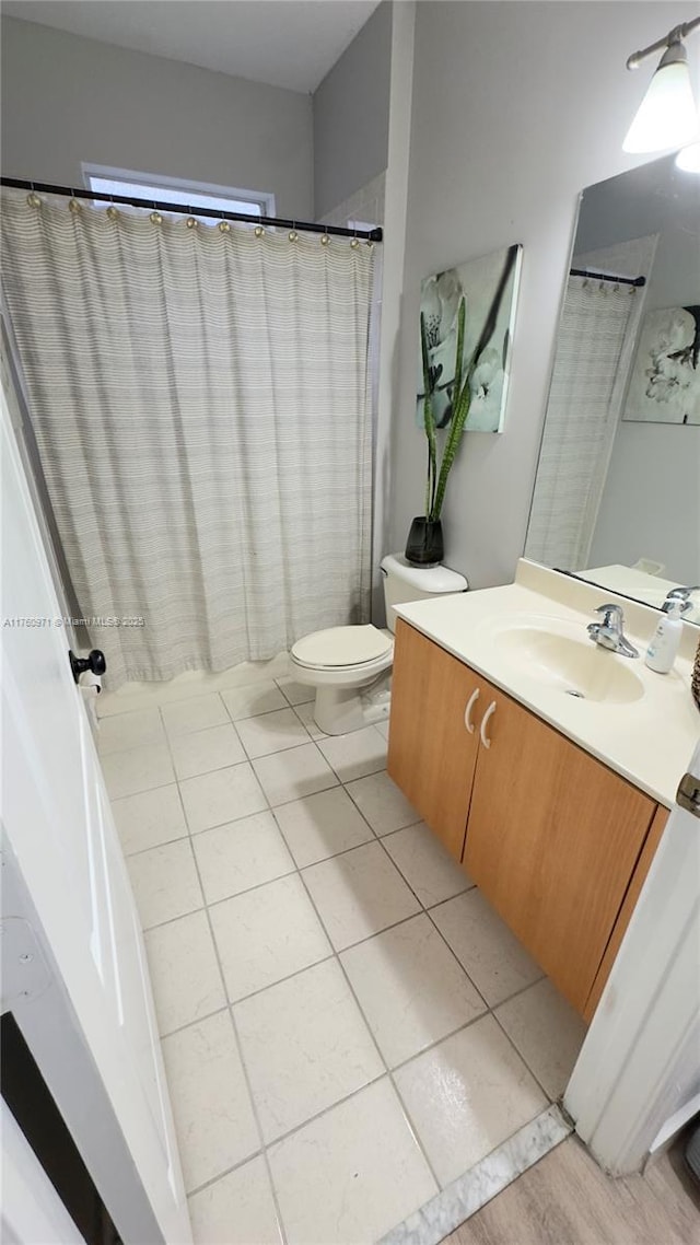 full bathroom featuring tile patterned floors, toilet, and vanity