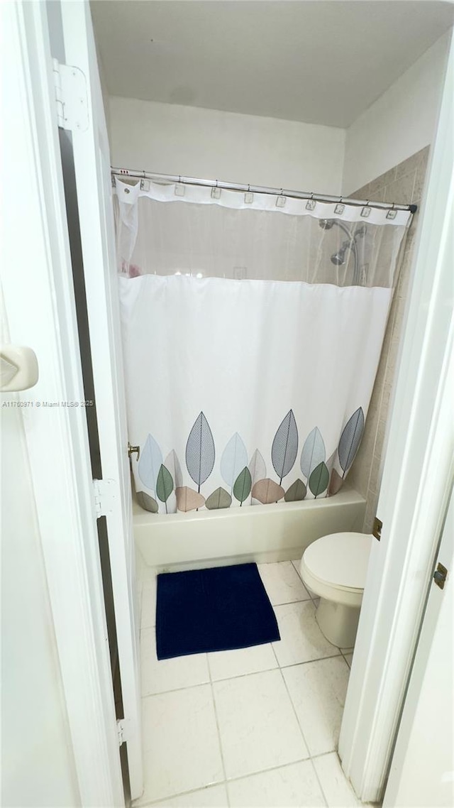 bathroom featuring tile patterned flooring, toilet, and shower / bath combo
