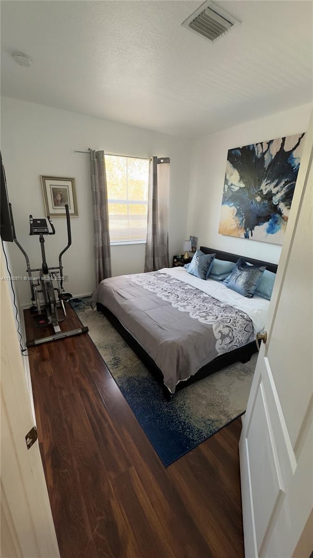 bedroom featuring visible vents and wood finished floors