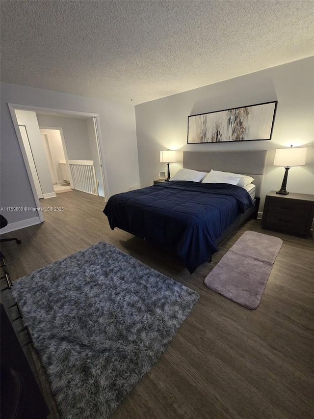 bedroom featuring wood finished floors and a textured ceiling