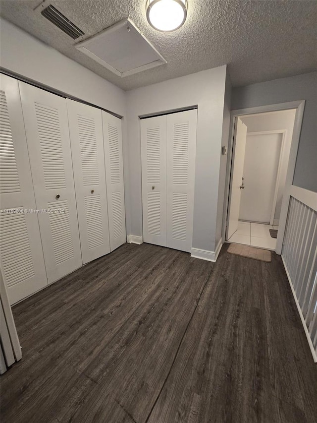 unfurnished bedroom featuring wood finished floors, visible vents, and a textured ceiling