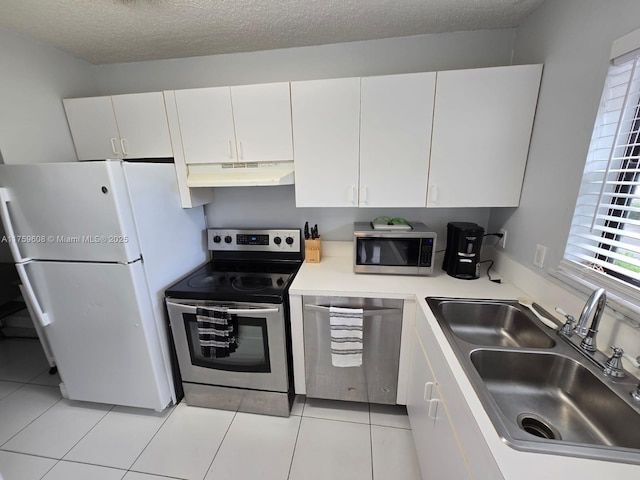 kitchen with under cabinet range hood, light countertops, white cabinets, stainless steel appliances, and a sink