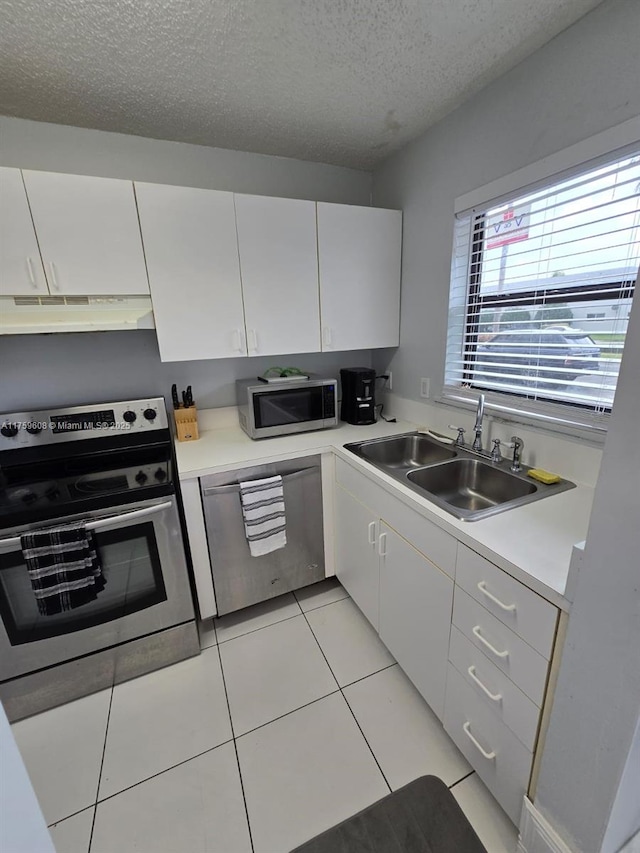 kitchen with a sink, light countertops, under cabinet range hood, and stainless steel appliances