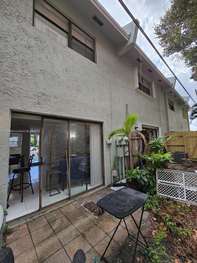 back of house with a patio area, stucco siding, a lanai, and fence