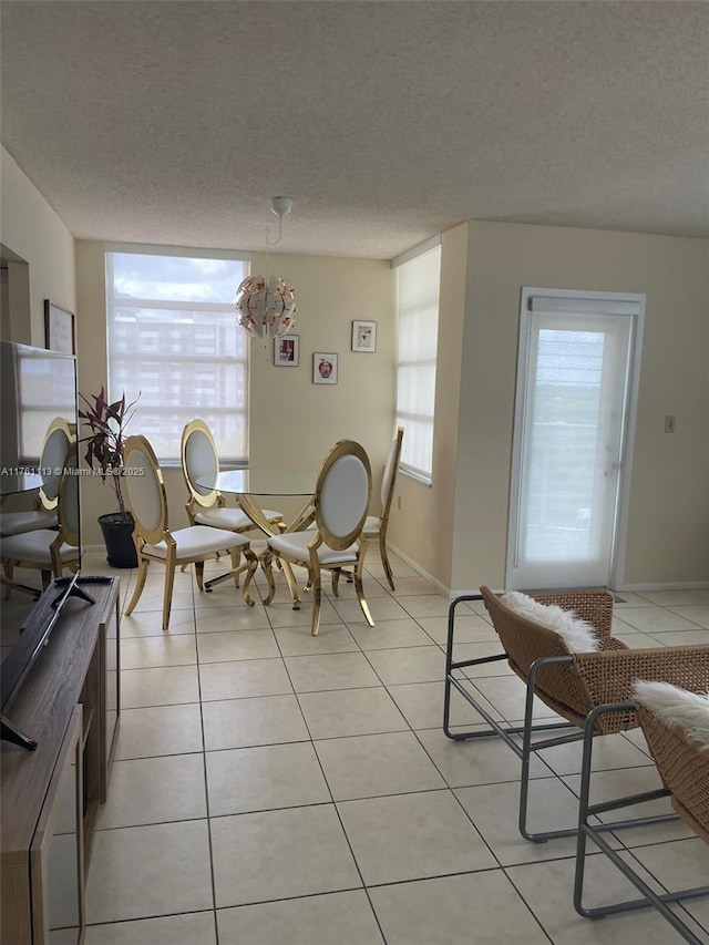 dining area featuring plenty of natural light, a notable chandelier, and light tile patterned flooring