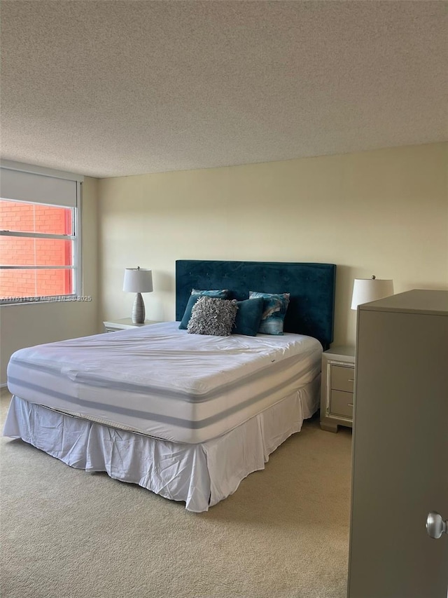 bedroom with light colored carpet and a textured ceiling