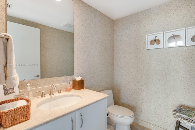 bathroom featuring visible vents, toilet, and vanity