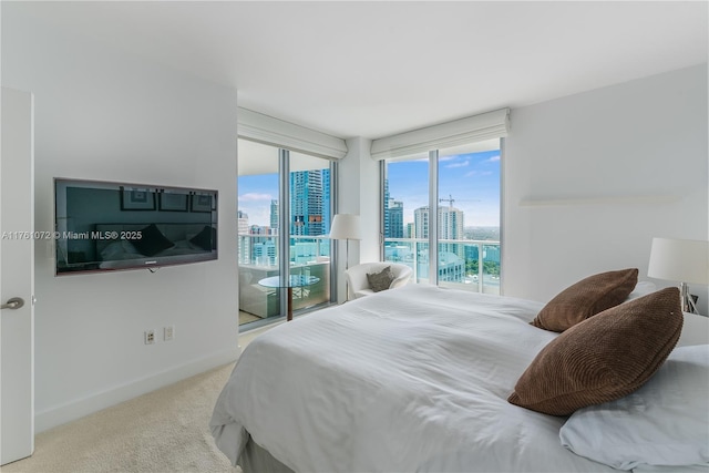 carpeted bedroom with access to exterior, a view of city, and baseboards