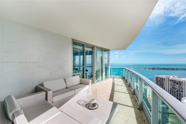 balcony featuring an outdoor living space and a water view