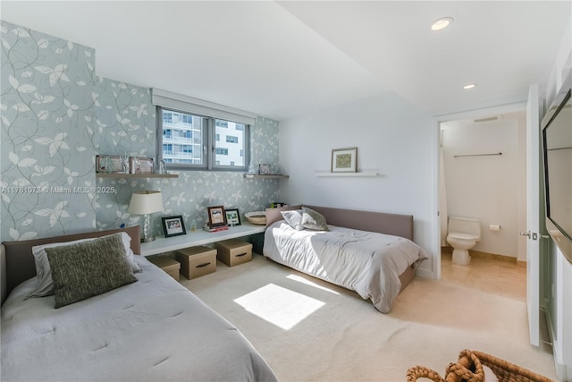 carpeted bedroom with wallpapered walls, an accent wall, baseboards, recessed lighting, and ensuite bathroom