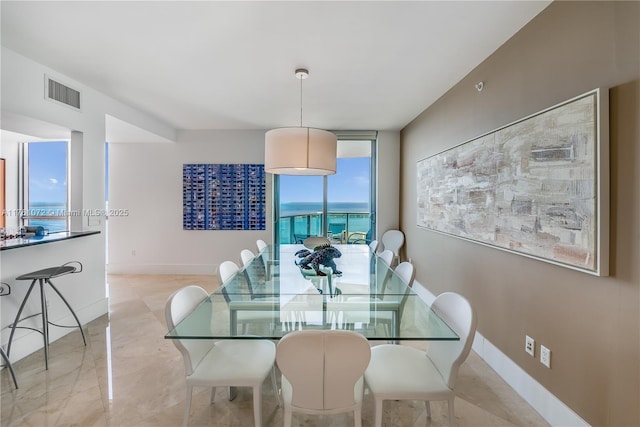 dining space with visible vents, floor to ceiling windows, marble finish floor, and baseboards