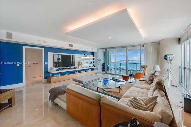 living area with visible vents, baseboards, and floor to ceiling windows