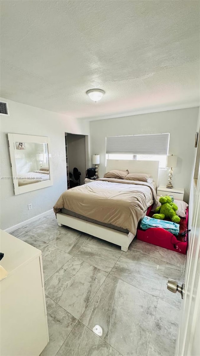 bedroom with visible vents and a textured ceiling