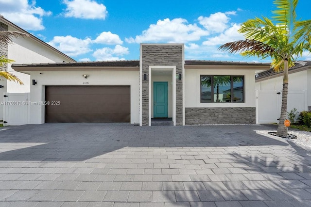 view of front of property with stone siding, stucco siding, decorative driveway, and a garage