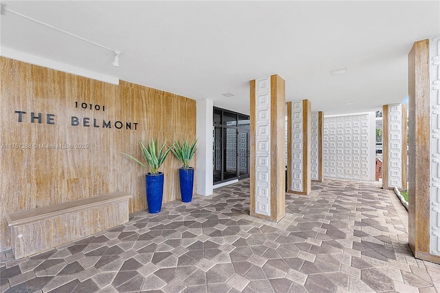 hallway featuring wood walls