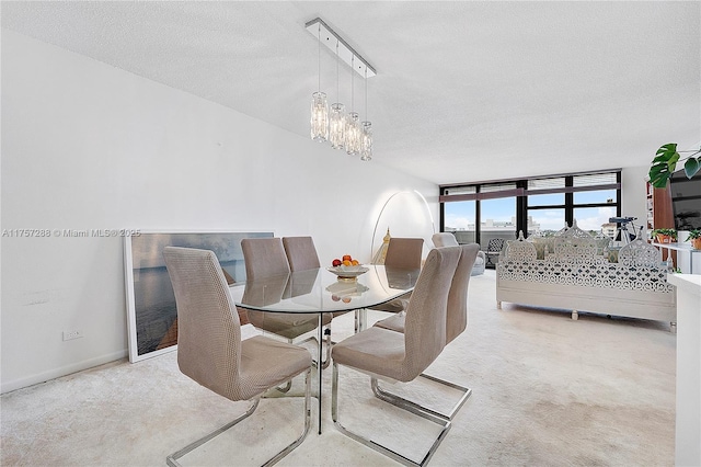 dining room with a chandelier, a textured ceiling, and carpet