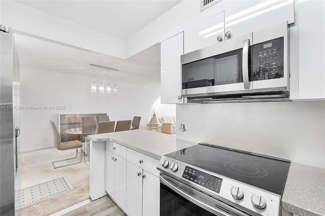 kitchen featuring white cabinets, appliances with stainless steel finishes, and light countertops