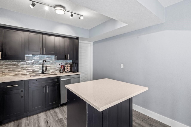 kitchen featuring a sink, backsplash, baseboards, light wood-type flooring, and stainless steel dishwasher