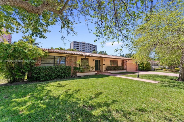 ranch-style house featuring stucco siding, a tiled roof, and a front lawn