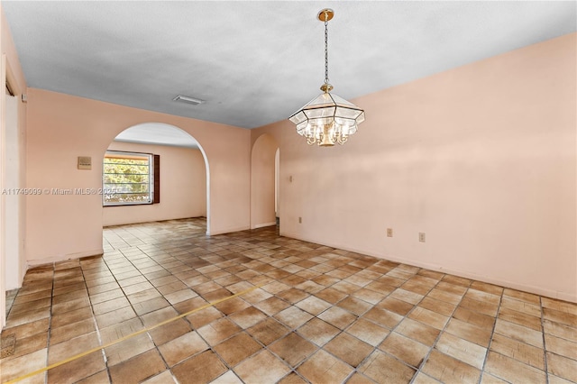 unfurnished room with light tile patterned floors, visible vents, arched walkways, and a chandelier