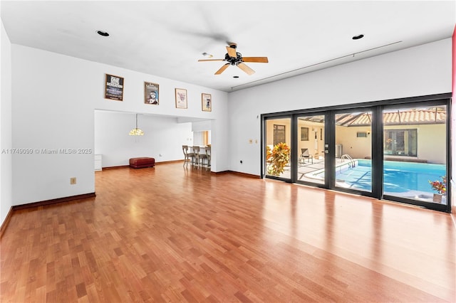 empty room featuring ceiling fan, baseboards, and wood finished floors