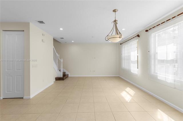 empty room featuring visible vents, baseboards, light tile patterned flooring, recessed lighting, and stairs