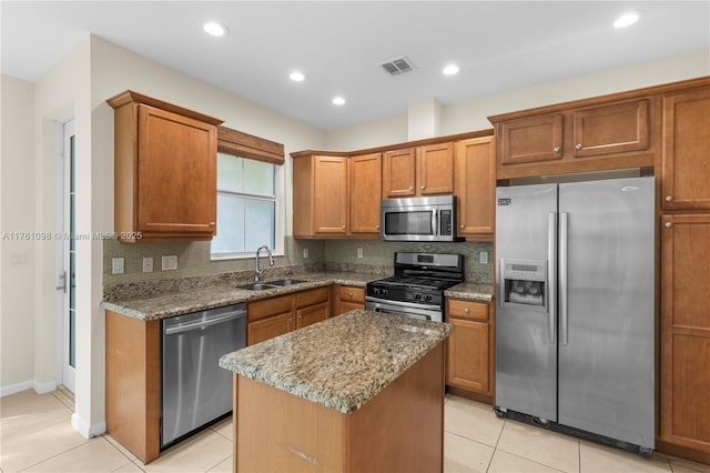 kitchen with visible vents, a sink, tasteful backsplash, appliances with stainless steel finishes, and light stone countertops