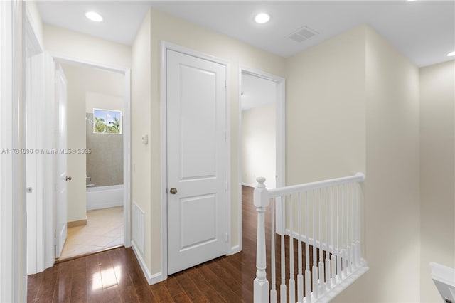 corridor featuring hardwood / wood-style flooring, recessed lighting, an upstairs landing, and visible vents