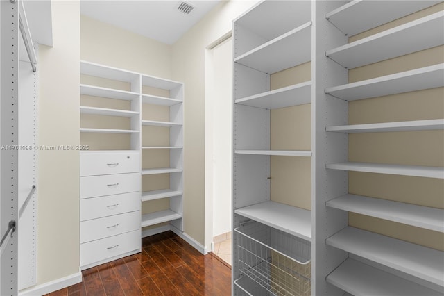 walk in closet featuring dark wood finished floors and visible vents