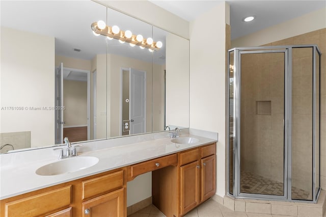 bathroom featuring tile patterned floors, a stall shower, and a sink