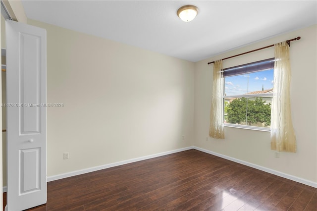 empty room with dark wood-style floors and baseboards