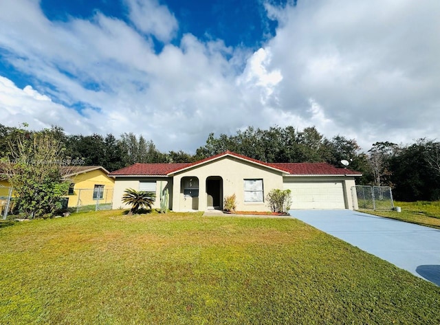 mediterranean / spanish-style house featuring a front yard, concrete driveway, fence, and stucco siding