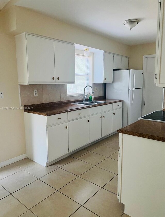 807 Mountbatten Ln, Kissimmee, FL 34758 - kitchen featuring a sink, dark countertops, light tile patterned flooring, and freestanding refrigerator