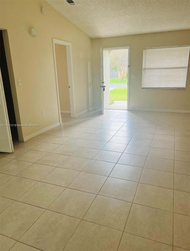 807 Mountbatten Ln, Kissimmee, FL 34758 - unfurnished room with light tile patterned floors, baseboards, a textured ceiling, and lofted ceiling