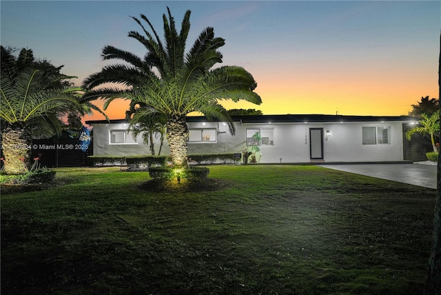 rear view of property with a patio, a yard, and stucco siding