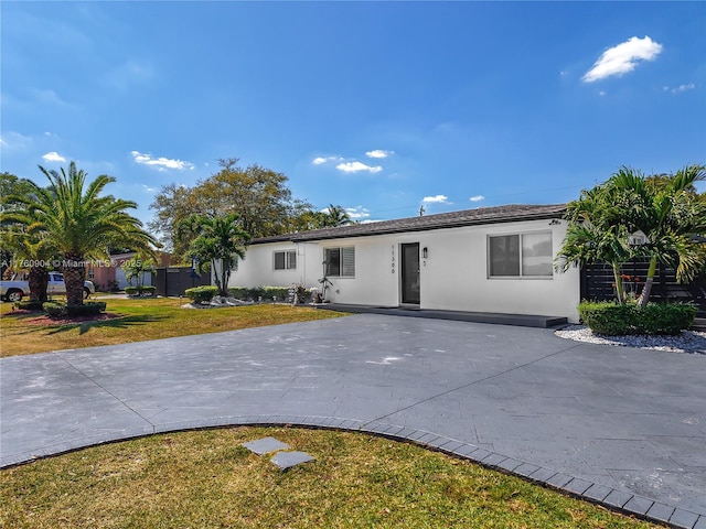 ranch-style house with a front lawn and stucco siding