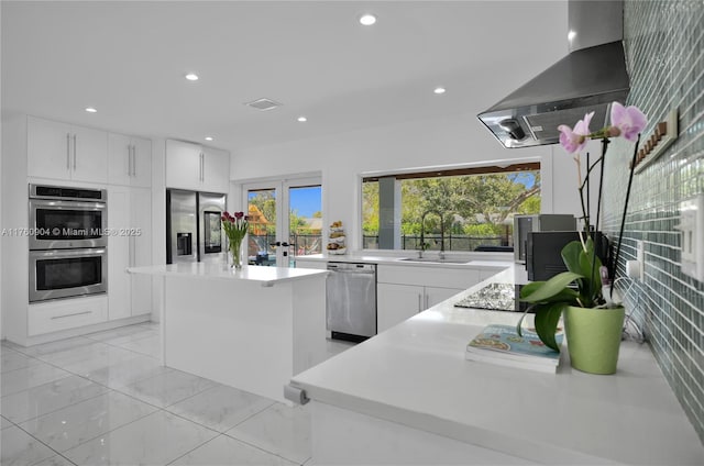 11300 SW 107th Ave, Miami, FL 33176 - kitchen with stainless steel appliances, a sink, wall chimney exhaust hood, white cabinets, and a kitchen island