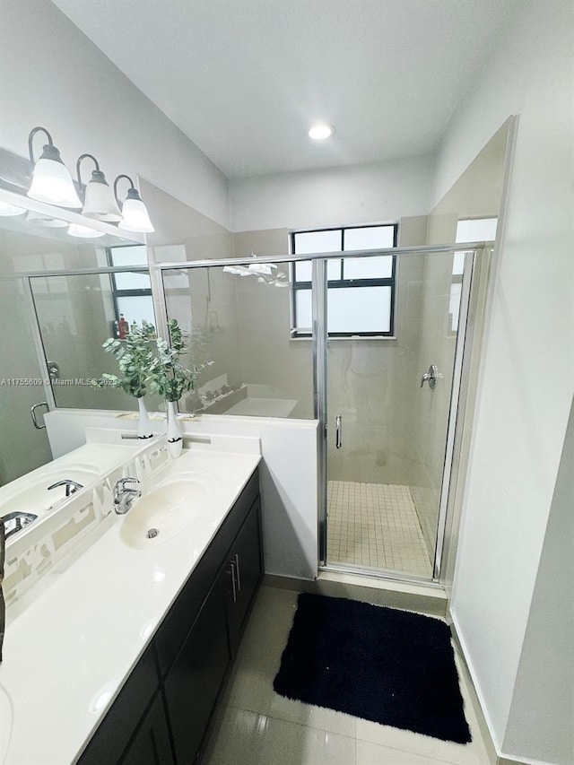 bathroom featuring vanity, a shower stall, baseboards, and tile patterned flooring