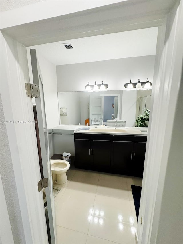 bathroom featuring visible vents, toilet, vanity, and tile patterned flooring