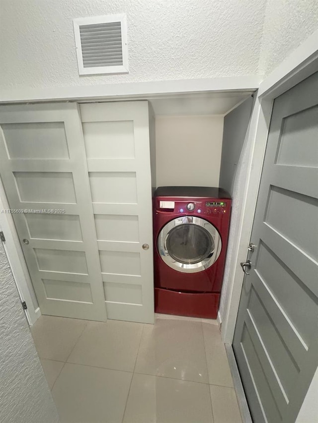 laundry room with tile patterned floors, laundry area, washer / clothes dryer, and visible vents