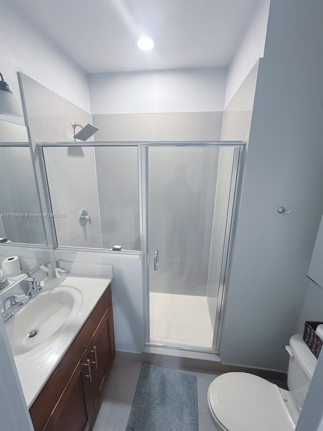 bathroom with toilet, a stall shower, and vanity