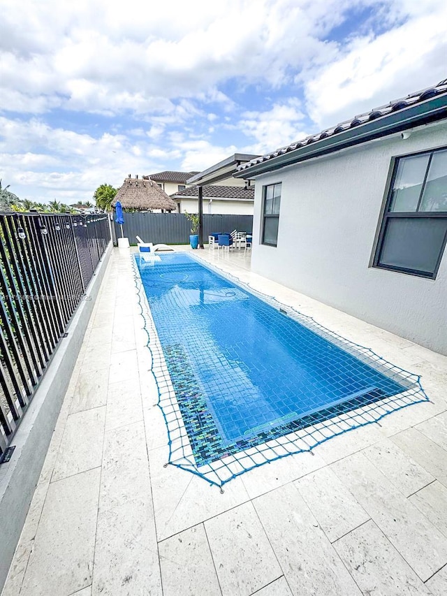 view of swimming pool featuring a patio area, a fenced in pool, and a fenced backyard