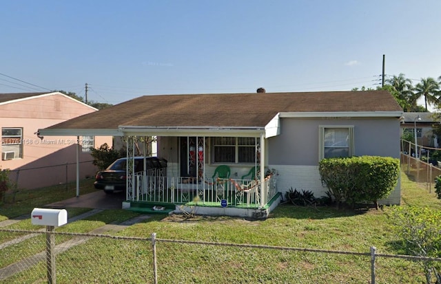 bungalow featuring a front yard, fence, a shingled roof, stucco siding, and brick siding