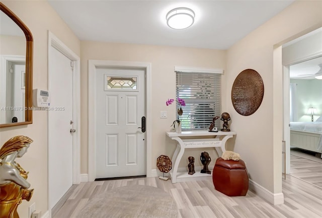 foyer featuring baseboards and wood finished floors