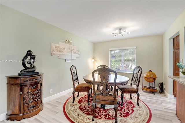 dining space with baseboards and light wood finished floors