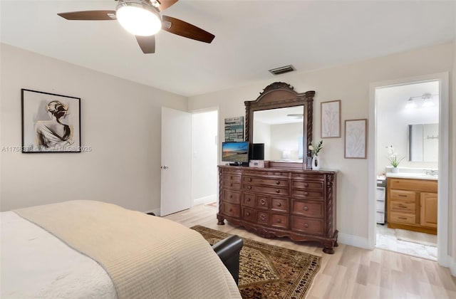 bedroom featuring a ceiling fan, visible vents, baseboards, ensuite bath, and light wood-style flooring